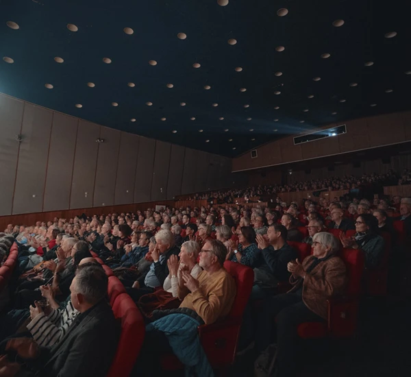 En fullsatt Odda kino med publikumere som smiler mot scenen. Foto.